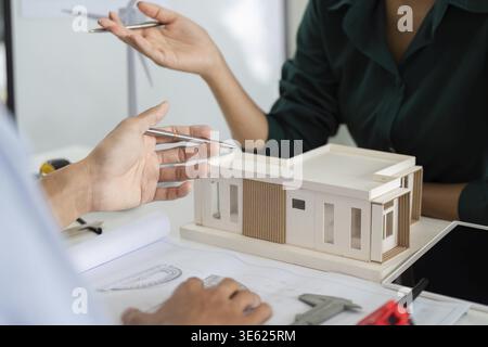 Architects collaborating on a sustainable building model, emphasizing environmental responsibility and innovative design Stock Photo