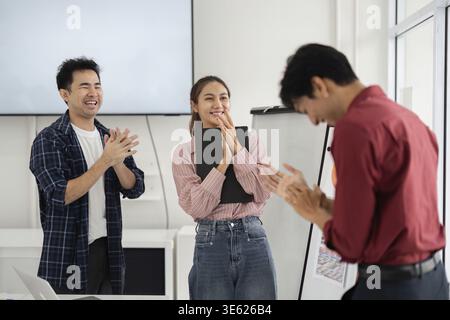 In an inspiring environment, team members applaud their colleague's ideas, highlighting an atmosphere of appreciation and collaborative spirit in the Stock Photo