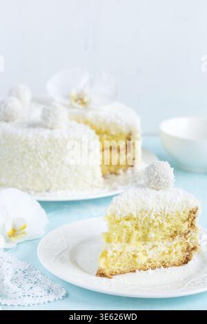 Food, Piece festive lemon and coconut sponge cake, selective focus Stock Photo