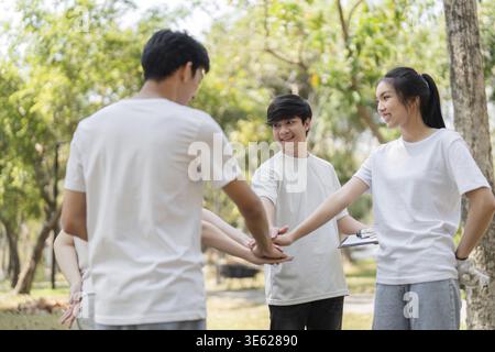 A group of engaged young volunteers collaborates in a park, preparing for their cleanup initiative while promoting teamwork and community spirit Stock Photo