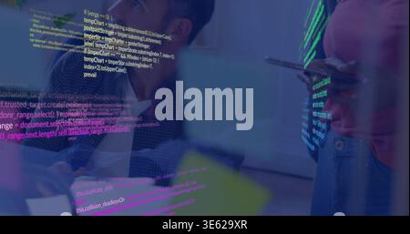 Reviewing code, three-person team leaning near glass display, presenter in pink top holding tablet Stock Photo