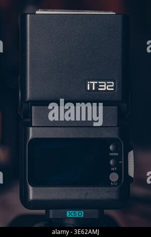 Godox iT32 camera flash speedlight showing rear control panel and LCD screen, mounted on a stand, close-up details Stock Photo