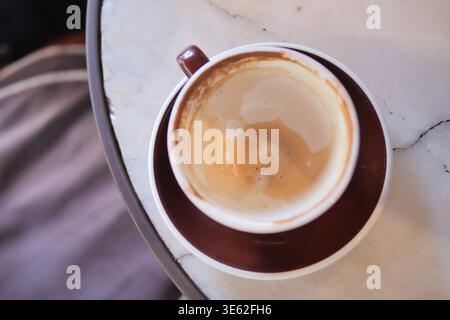 Coffee cup sits empty on a table after morning drink Stock Photo