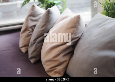 Pillows arranged on a sofa by a window in a bright room Stock Photo