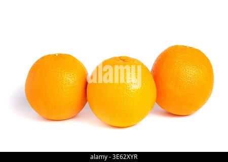 Group of three ripe whole oranges arranged on a white background. Concept of healthy grocery and fruit variety. Stock Photo