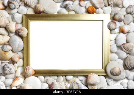 Coastal themed gold frame mockup surrounded by natural sea stones and shells. Blank canvas for nautical and summer holiday designs. Stock Photo