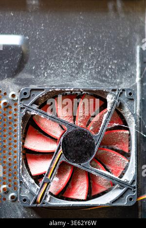 Frontal view of a red computer fan covered in thick layers Stock Photo