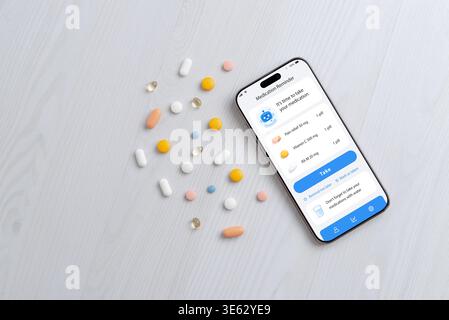 Smartphone displaying medication reminder app with pills, digital health and healthcare technology concept Stock Photo