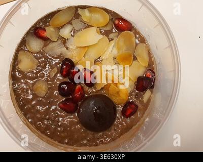 A close-up overhead view of a chocolate-colored breakfast bowl or dessert served in a clear plastic container. The dish appears to be oatmeal, chia Stock Photo