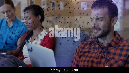 Working right-side man orange check shirt typing on silver laptop in lounge, tablet, copy space Stock Photo