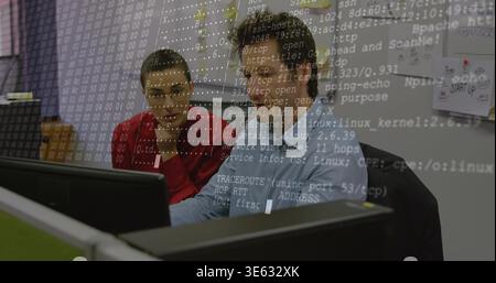 Working IT colleagues reviewing code at desk with terminal overlay, in red sweater, blue shirt Stock Photo
