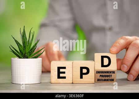 Businessman turns a wooden block with the symbol EPD, Environmental Product Declaration. Data on the products impact on the environment throughout its Stock Photo