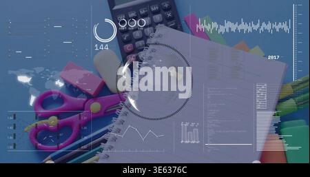 Displaying spiral-bound lined notebook angled on blue desk, showing stationery and HUD overlay Stock Photo
