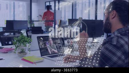 Watching bearded man wearing plaid using laptop at office, woman on screen holding mug, copy space Stock Photo