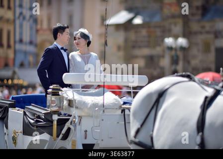 Bride and groom standing in a white horse-drawn carriage on a cobblestone square in Old town of Prague, Czech Republic on 12 August 2024 Stock Photo