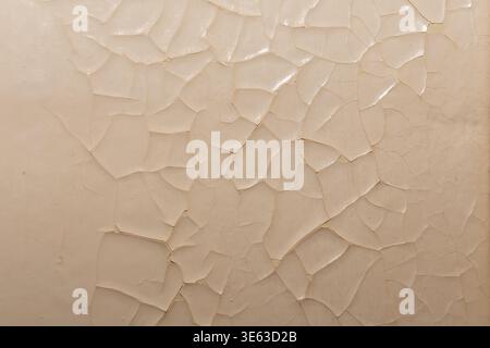 Old paint peeling on wall forming pattern of damaged surface material. Stock Photo