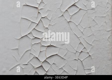 White paint on wall cracked creating contrast texture of aged surface. Stock Photo
