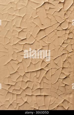 Peeling paint on wall creates pattern of worn surface and material defects. Stock Photo
