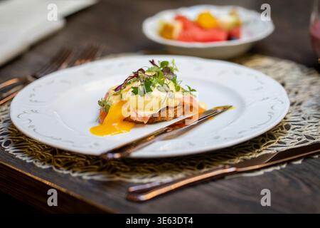 Eggs Atlantic with runny poached egg, smoked salmon and creamy hollandaise sauce on toasted bread. Gourmet brunch dish featuring poached egg. Stock Photo