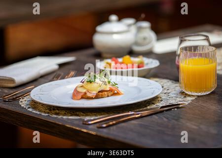 Eggs Atlantic with runny poached egg, smoked salmon and creamy hollandaise sauce on toasted bread. Gourmet brunch dish featuring poached egg. Stock Photo