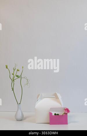 Minimal gift box with pink envelope and flower, elegant still life composition with copy space Stock Photo