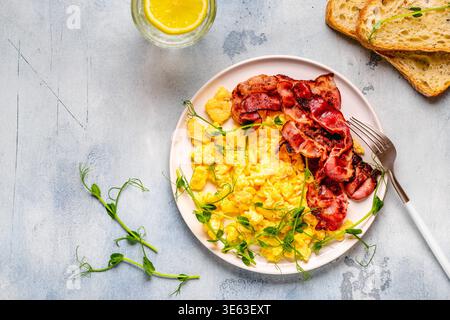 Traditional breakfast scrambled eggs with fried bacon. Top view. Stock Photo