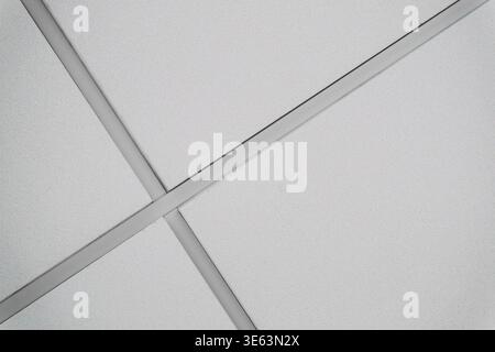 White ceiling tile with grid and textured surface making a diagonal lines. Stock Photo