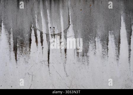 Grungy weathered concrete wall with dripped water, displaying vertical water stains and drip patterns Stock Photo