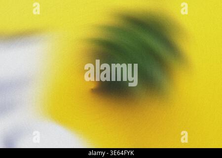 Blurry image of a green leaf on a yellow background with white and purple colors, soft focus and textured surface Stock Photo