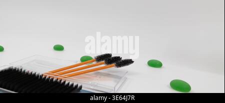 Eyelash brushes and lash tray with green decorative elements on light background beauty tools composition Stock Photo