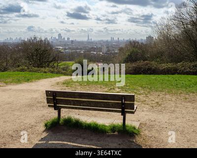 Empty park bench with city skyline view at the top of Parliament Hill on Hampstead Heath, London, UK Stock Photo