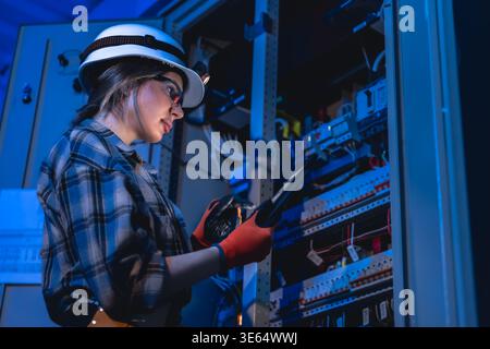 Female engineer inspecting electrical network using tablet. Technical control. Stock Photo