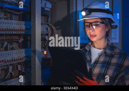 Electrical specialist inspecting power system with tablet. Engineering control. Stock Photo