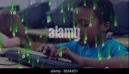 Typing boy in blue tee focusing on keyboard in school computer lab with monitors, binary overlay Stock Photo