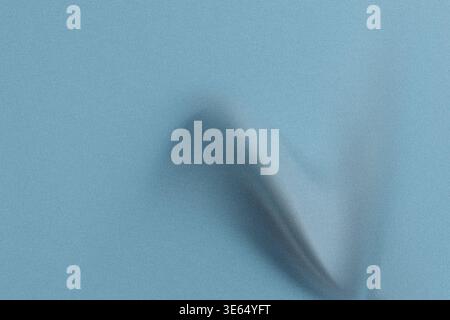 A light blue background with a dark shadowy figure in the center, creating a sense of contrast and visual interest with a textured surface and subtle Stock Photo