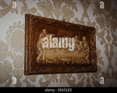 Carved wood religious relief showing Jesus and the 12 apostles at The Last Supper on a patterned wall Stock Photo