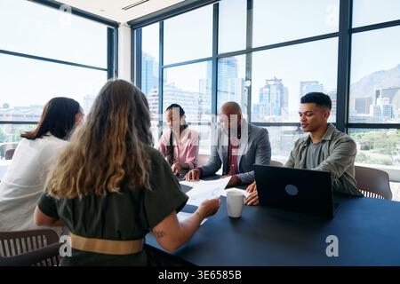 Diverse team of professionals having discussion in boardroom at office during daytime Stock Photo