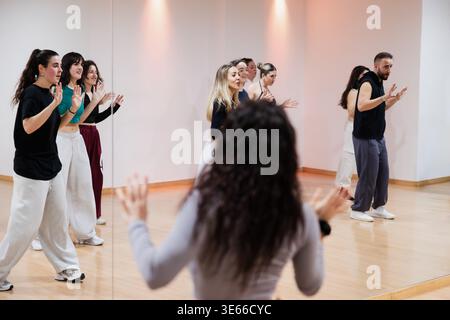 Dancers rehearsing choreography in mirror reflection studio Stock Photo