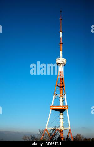 Full vertical view of a red and white broadcasting transmitter tower standing tall in daylight. Stock Photo