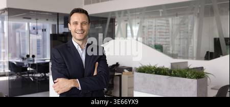 Confident smiling mid aged businessman posing for portrait in office Stock Photo