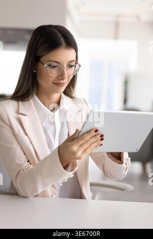 Elegant woman using digital tablet at workplace Stock Photo