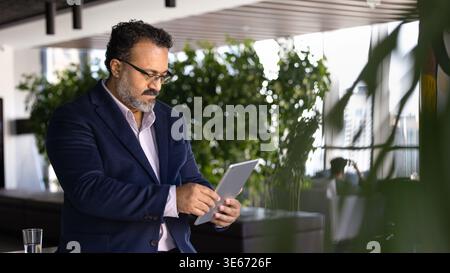Focused executive reviewing data on digital tablet Stock Photo