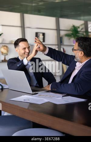 Two happy businessmen, team members exchanging high-five Stock Photo