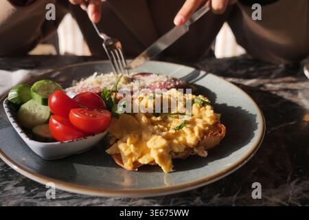 Breakfast with eggs on toast, salad, and meat in a cafe Stock Photo
