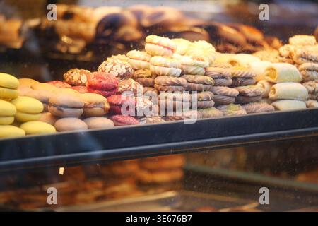 Baked goods on display in a shop window in the afternoon Stock Photo