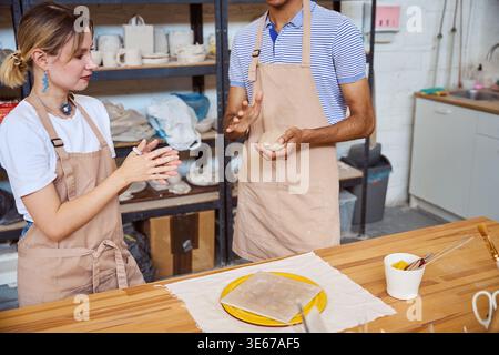 Young adults engaging in pottery at creative studio Stock Photo