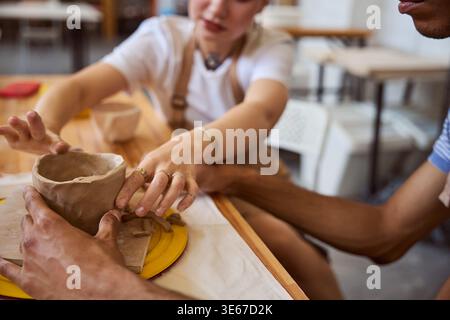 Two adults creating pottery in art studio during daytime Stock Photo