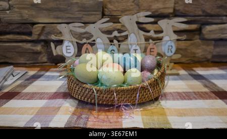 Easter Basket with Colorful Eggs and Spring Decorations Stock Photo