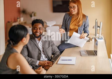 Team of professionals exchanging ideas and collaborating on project with documents and laptop in boardroom Stock Photo