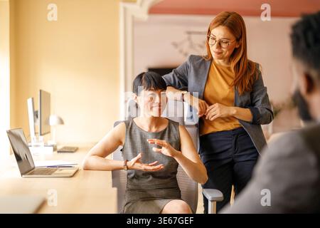 Group of professionals actively discussing strategies and solutions while collaborating in modern workplace Stock Photo